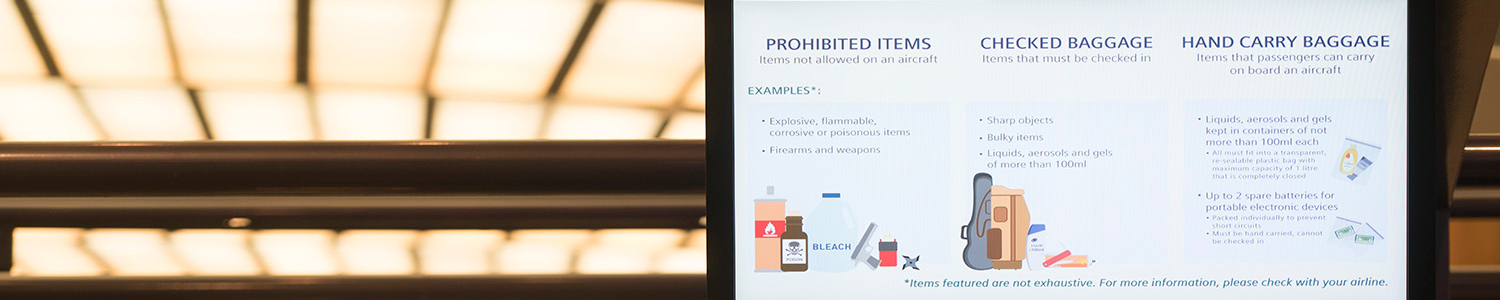 Photo of screen at check-in counter showing list of items that should and should not be packed in luggage.